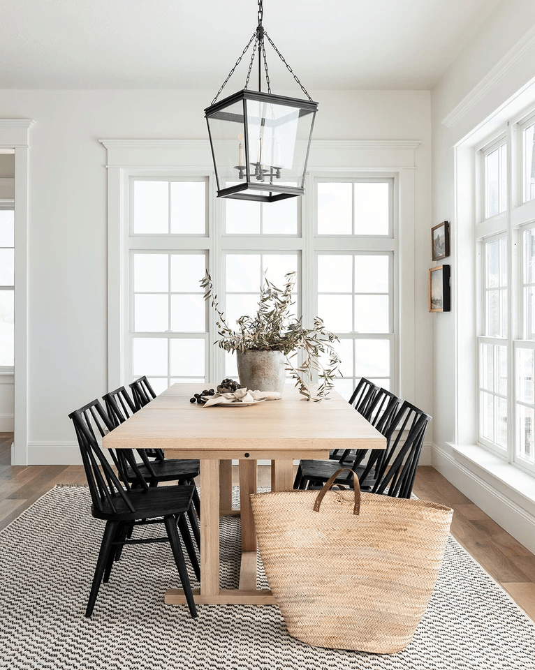 similar table, natural wood, with black chairs. Pattered rug, Brass light fixture similar style.